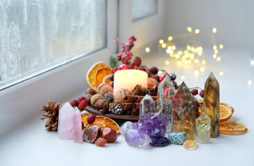 Gemstones crystals, candle, natural festive winter decor on windowsill. minerals for Witchcraft...