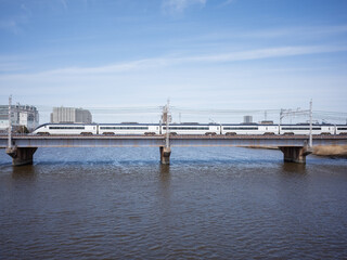 Fototapeta na wymiar train bridge on the river and blue sky in katsushika ward
