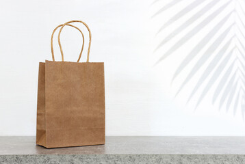 Empty table and brown shopping bag over white background