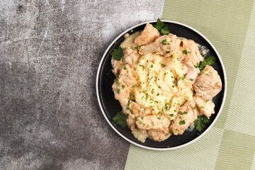Mashed potatoes with Chicken stew on a plate on a dark background. Top view, flat lay