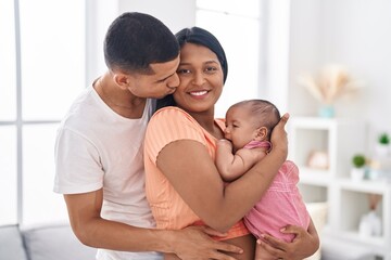 Fototapeta premium Hispanic family hugging each other kissing at home