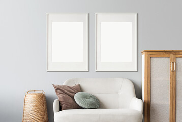Blank picture frame mockup on gray wall. Modern living room design. View of modern Boho style...