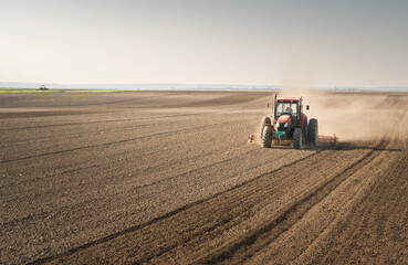 Tractor is preparing the land at dusk