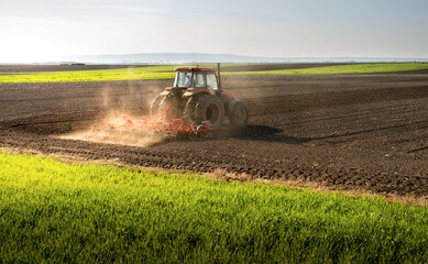 Obraz premium Tractor is preparing the land at dusk