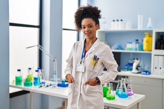 Young african american woman wearing scientist uniform standing at laboratory