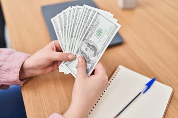 Young beautiful plus size woman counting dollars at office