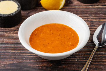 Lentil soup in white porcelain bowl on wooden table