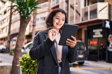 Young woman smiling confident using touchpad at street