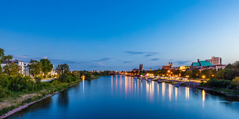 Germany, Saxony-Anhalt, Magdeburg, Long exposure of Elbe river flowing through city at dusk