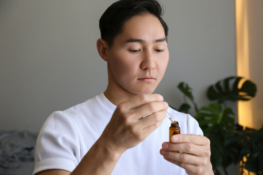 Young man holding serum at home