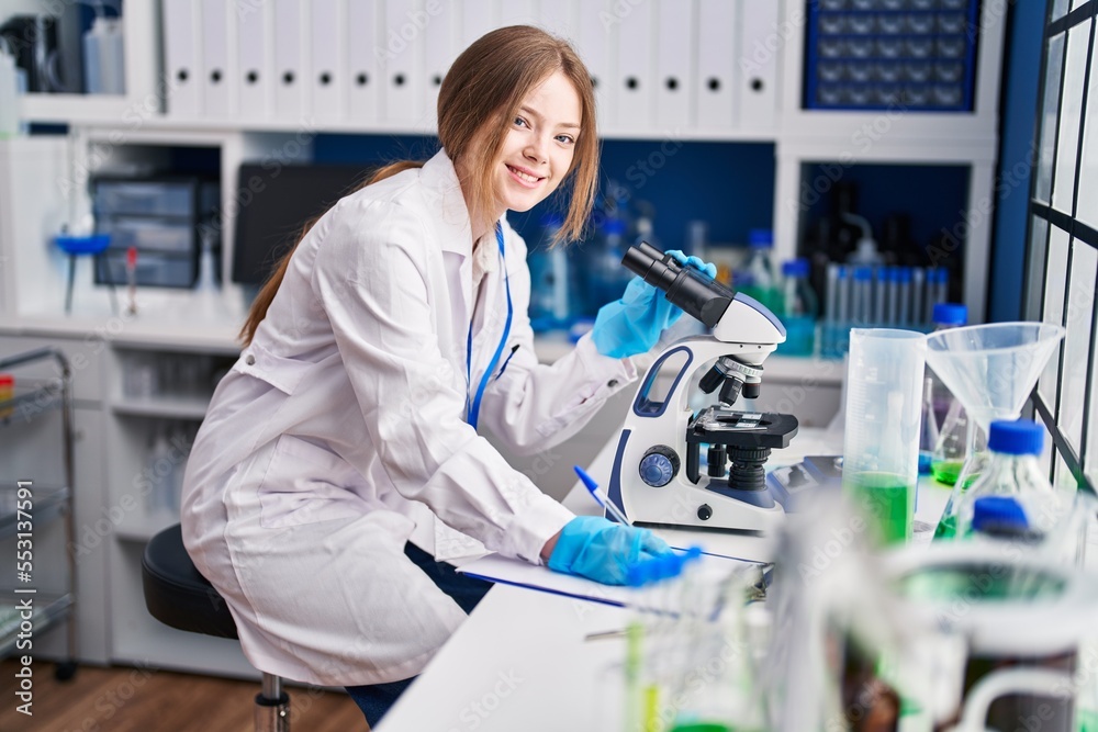 Sticker Young caucasian woman scientist using microscope write on document at laboratory