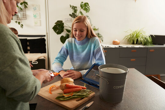Happy girl with mother preparing food at home