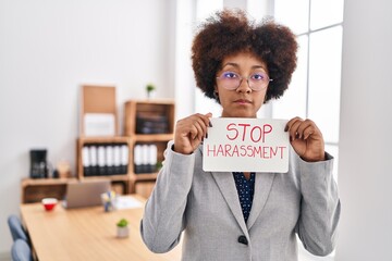 African american woman business worker holding stop harassment message banner at office