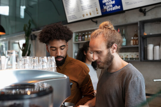 Barista and colleague working in cafe