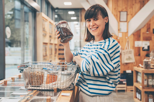 Smiling customer with kidney beans jar at counter in convenience store