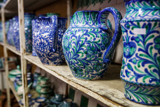 Designed pitchers arranged on rack in factory