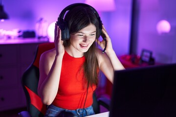Young caucasian woman streamer smiling confident sitting on table at gaming room