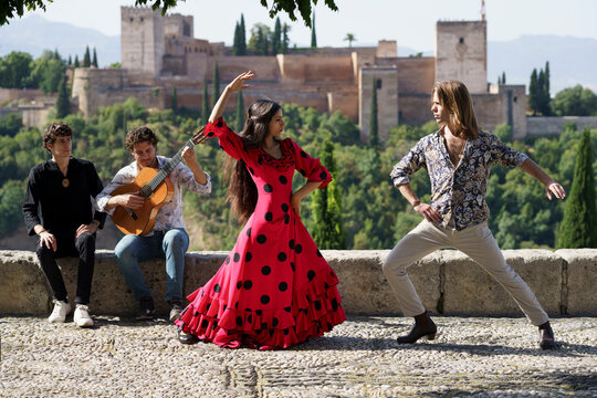 Dancers and musician performing flamenco on sunny day in front of Alhambra, Granada, Spain