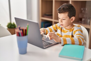 Blond child studying sitting on table at home