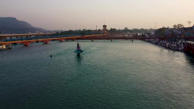isolated iron bridge many over ganges river with wide view of city at riverbank at evening aerial video is taken at har ki pauri haridwar uttrakhand india on Mar 15 2022.