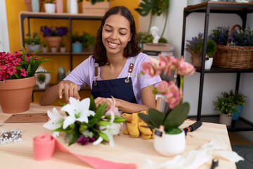 Young african american woman florist make bouquet of flowers at flower shop