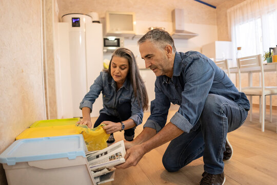 Mature couple seperating waste at home