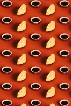 Three dimensional render of rows of dumplings and bowls of soy sauce flat laid against red background