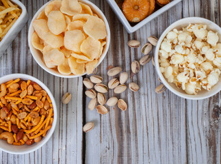 Party snacks, an assortment on rustic wood with copy space