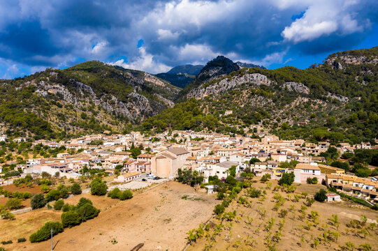Caimari village near Tramuntana mountains by field on sunny day
