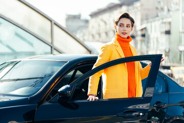 Beautiful young woman with short hair drives car in the city