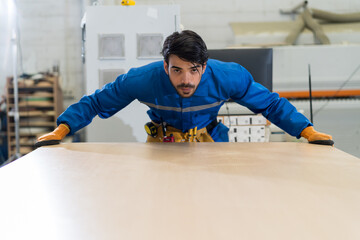Male carpenter worker working and checking wooden plank in the carpentry workshop. Industry...