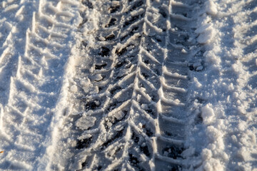 Obraz premium Car tire tracks. Snowy and icy road, dangerous and unsafe. Winter morning