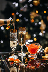 glass of champagne with red caviar appetizer cracker, butter and red caviar. banner, menu, recipe....