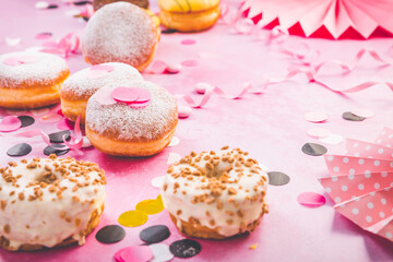 German Krapfen or donuts with streamers and confetti. Traditional Berliner for carnival and party