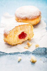 German donuts - berliner filled with strawberry jam with icing sugar