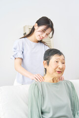 Fototapeta premium 祖母の肩揉みをする孫