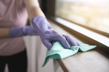 Woman's hand mopping the window sill