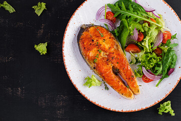 Roasted salmon garnished with fresh salad. Ketogenic lunch. Keto diet. Top view, above