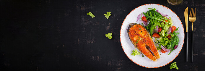 Roasted salmon garnished with fresh salad. Ketogenic lunch. Keto diet. Top view, banner