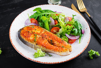 Roasted salmon garnished with fresh salad. Ketogenic lunch. Keto diet.