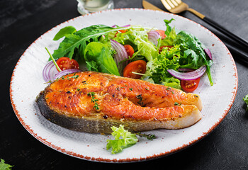 Roasted salmon garnished with fresh salad. Ketogenic lunch. Keto diet.