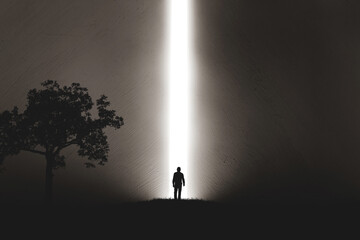 A silhouette of a man in nature next to a tree, walking towards a bright light in the opened huge wall. A light in the end of a tunnel. The concept of success, freedom, choice, open mind, meditation. - 553152702