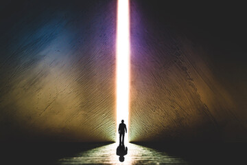 The silhouette of a man walking towards a bright light in the opened huge wall. A light in the end of a tunnel. The concept of success, freedom of choice, open mind, meditation. - 553152755