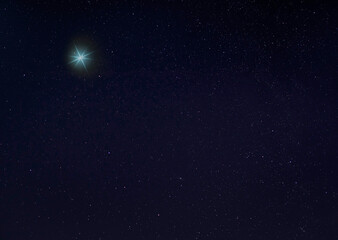 Obraz na płótnie Canvas Bright blue star for Christmas in the night sky