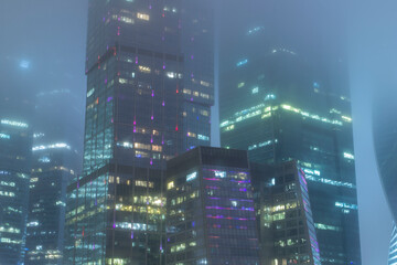 Skyscrapers are covered with fog. Mystical city landscape. Foggy view of the towers of the Moscow International Business Center Moscow City.