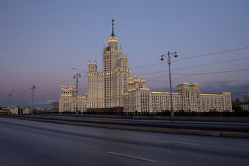 High-rise building on Kotelnicheskaya embankment. Stalinist architecture of the Soviet era. Stalin skyscraper illuminated at sunset. Evening urban landscape. Moscow, Russia.