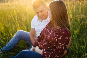 young happy beautiful couple in love walking together on grass and trees park landscape