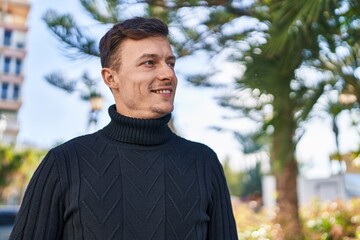 Young man smiling confident looking to the side at park