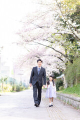 Fototapeta premium ランドセルを背負った女の子とスーツを着た父親