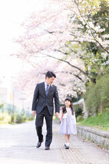 Fototapeta premium ランドセルを背負った女の子とスーツを着た父親